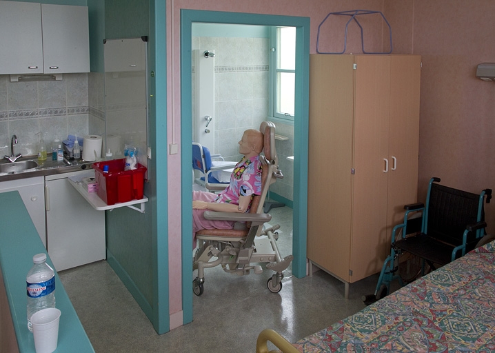 Bâtiment de l'hôtellerie (1er étage), hôpital pédagogique : salle de bain de la gériatrie, avec mannequin.
