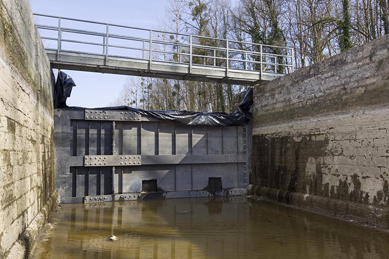 La porte de garde et le batardeau métallique.