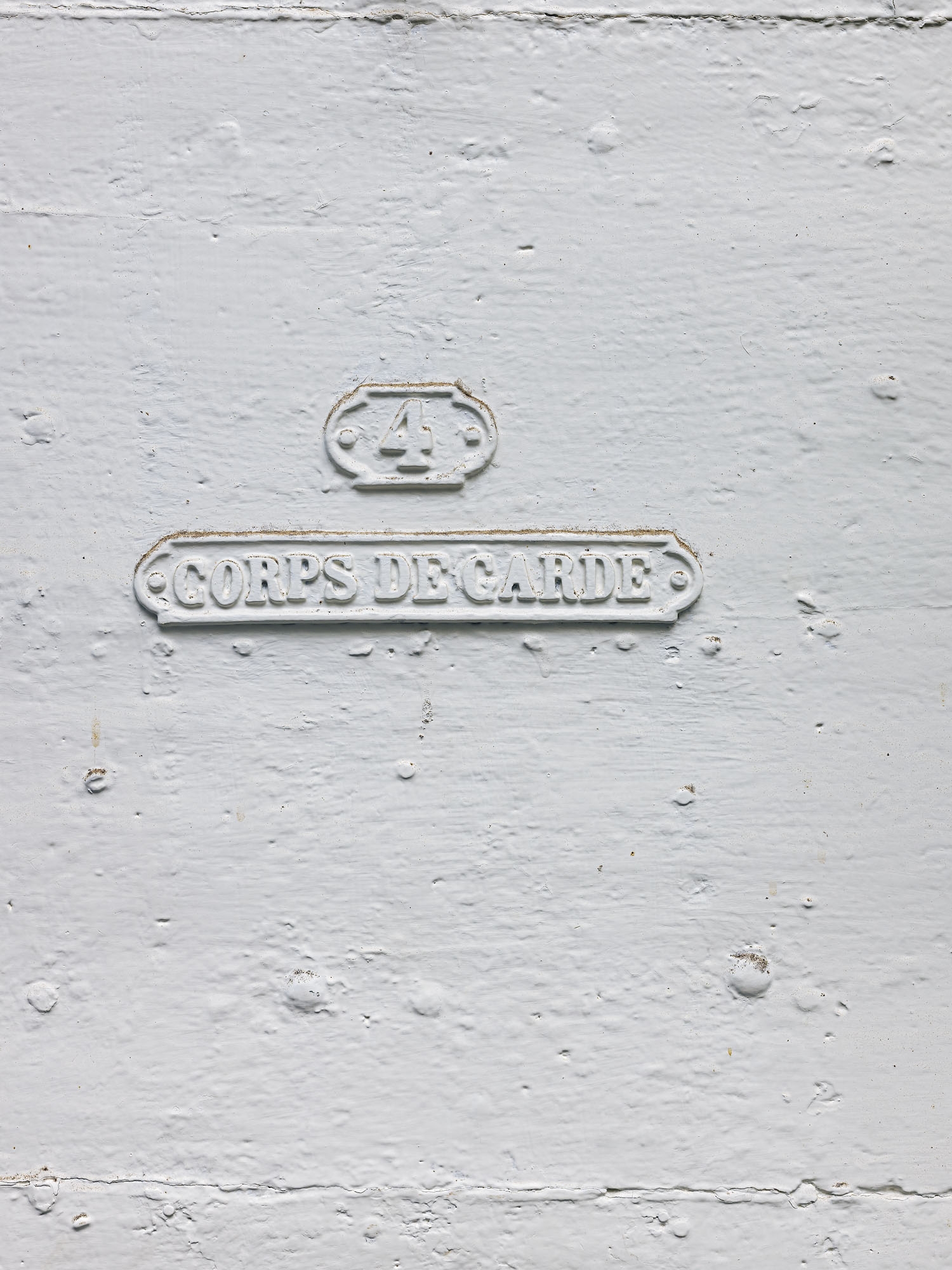 Le passage voûté : porte d'entrée du corps de garde (détail de l'inscription).