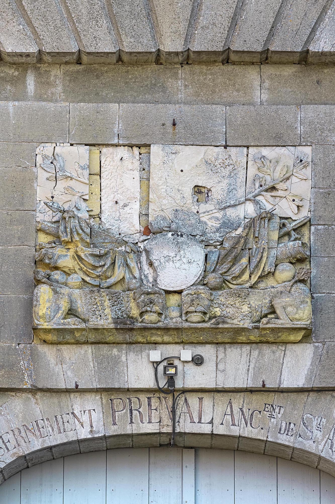 La porte d'entrée : détail de l'inscription et du bas relief.