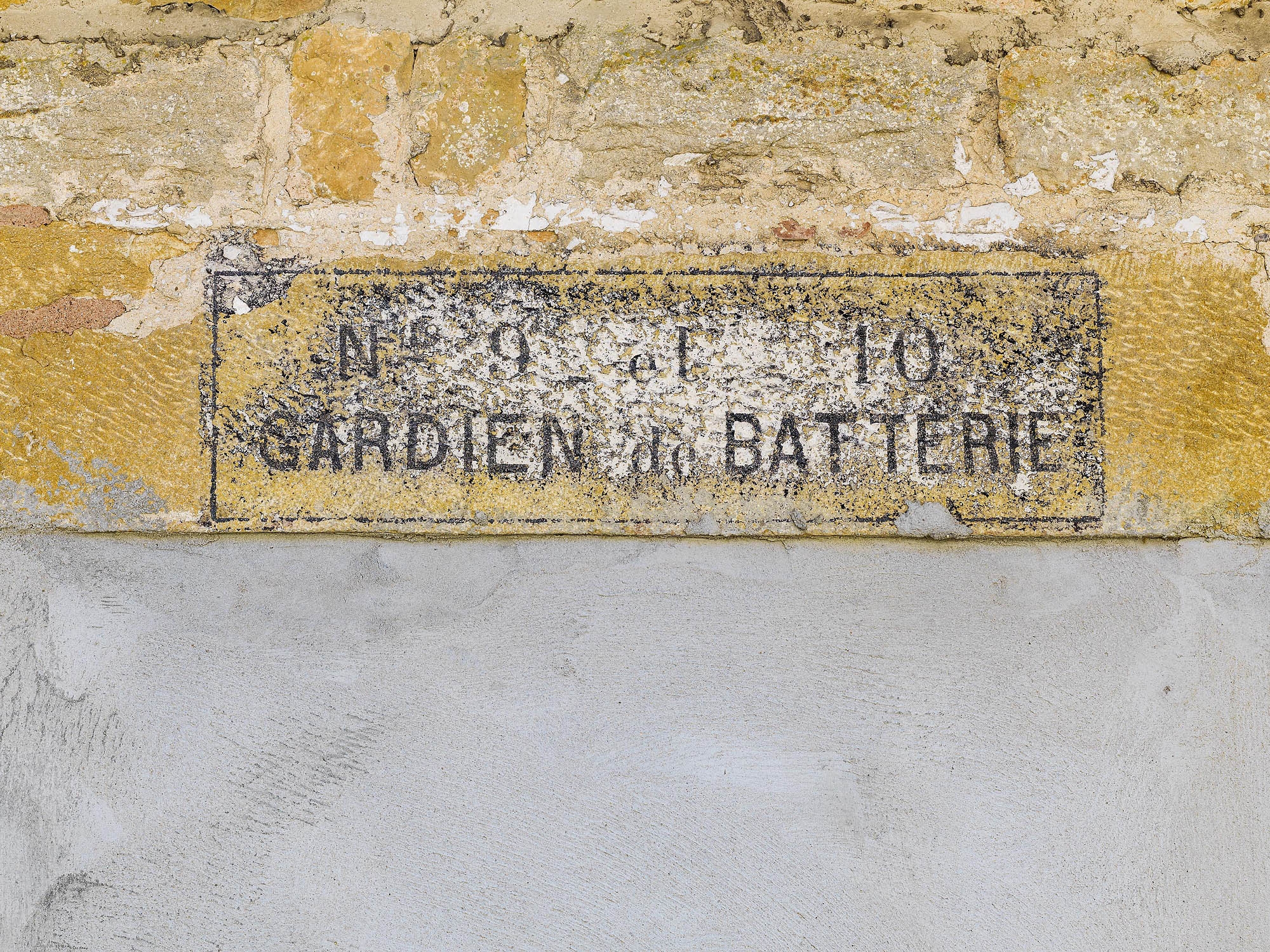 Graffiti dessiné sur le mur. ; Porte murée avec inscription "gardien de batterie".