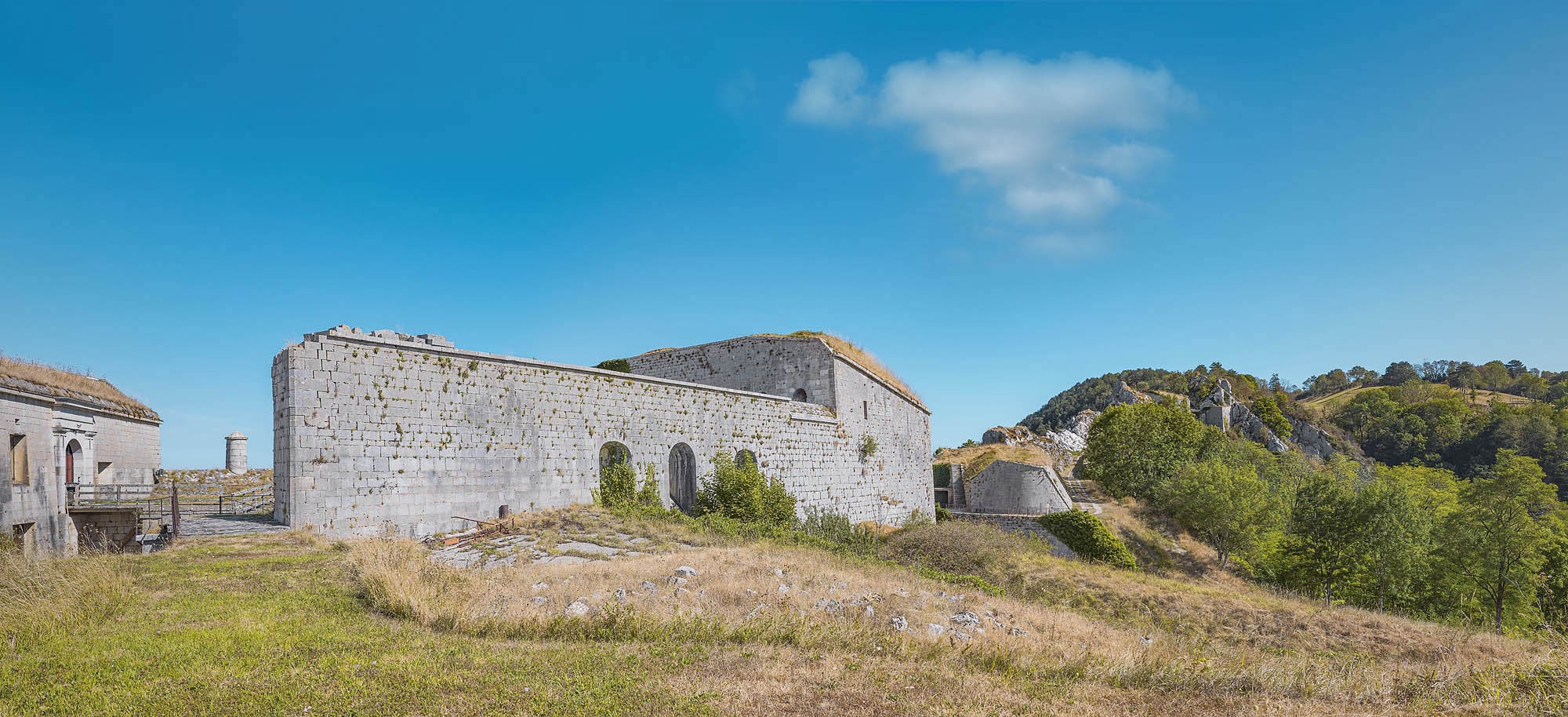 Le rempart en retour d'équerre du cavalier depuis le couvert végétal du bâtiment casematé servant de caserne et de magasins.