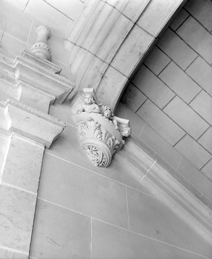 Logis, escalier, deuxième volée (détail) : culot décoré de deux personnages.