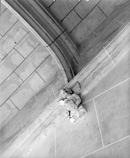 Logis, escalier, première volée (détail) : culot décoré d'un ange portant les armes des Rougé.