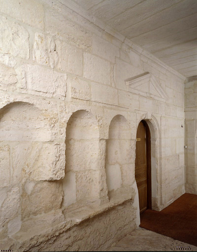 Vue du couloir du premier étage montrant la porte d'accès à la pièce, située du côté est, et les trois niches taillées dans le mur.