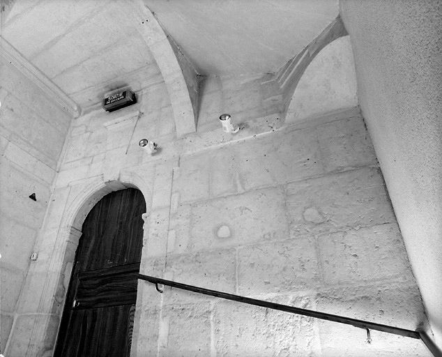 Vue du mur sud de la cage d'escalier montrant la porte d'accès à la pièce sur rue du premier étage et la trompe supportant l'escalier.