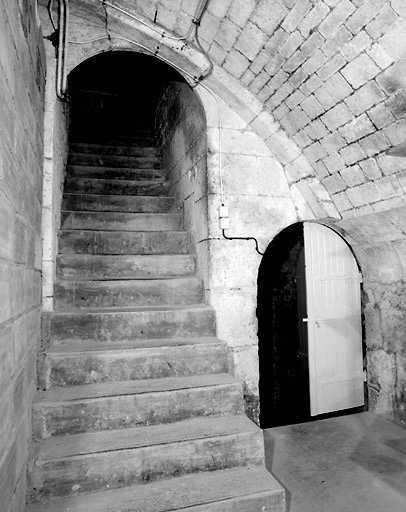 Escalier de descente au premier sous-sol; à droite, la porte d'accès à la descente au deuxième sous-sol.