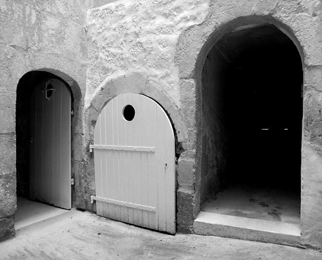 Vue prise de l'intérieur du puits de lumière. De gauche à droite : porte de la tourelle d'escalier, accès au sous-sol et porte du couloir du premier logis.