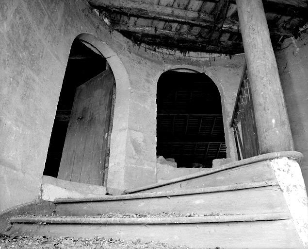 Vue de la partie supérieure de l'escalier montrant les portes d'accès à chacune des deux ailes, au niveau du comble.