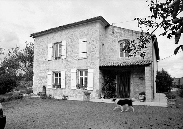 La façade sud-ouest de la maison. La porte d'entrée, sous l'auvent, est en plein cintre.