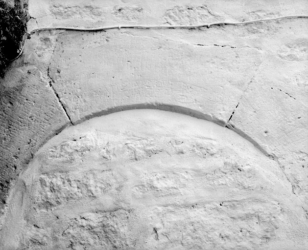Détail de la porte en plein cintre, avec inscription en latin.