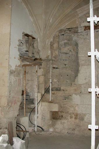 Logis B, salle voûtée du rez-de-chaussée, angle nord-ouest : dégagement d'un escalier en vis à gauche de la cheminée. Sur le mur ouest, dans l'espace du mini-vestibule, départ des premières marches. Chantier de restauration, 26 avril 2001.