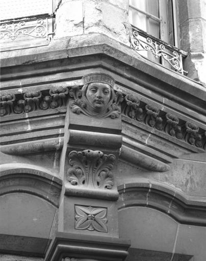 Façade sur cour, base de l'oriel : masque féminin et motifs végétaux