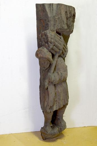 Vestige d'un poteau sculpté figurant un porteur de fagot. (Réserves des Musées d'Angers).