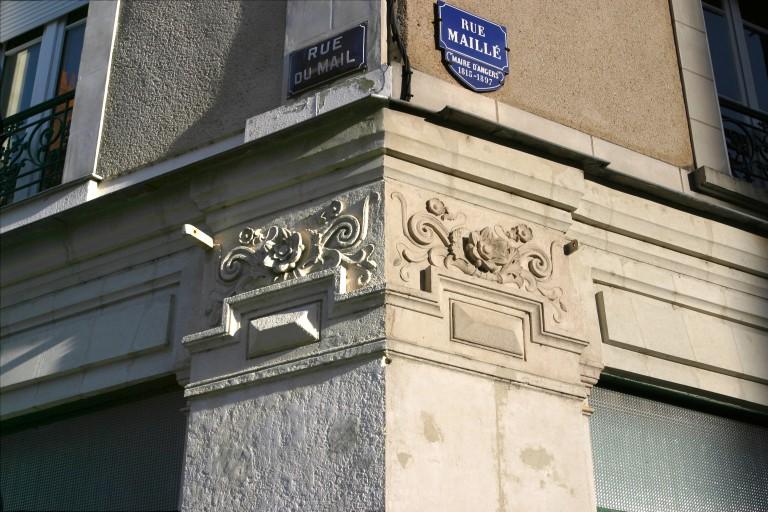 Façade sur rue : corps sculpté sur le pilier d'angle des deux rues.