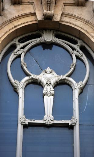 Façade des Nouvelles Galeries rue d'Alsace, avant-corps latéral droit : détail sur l'huisserie en bois de la baie