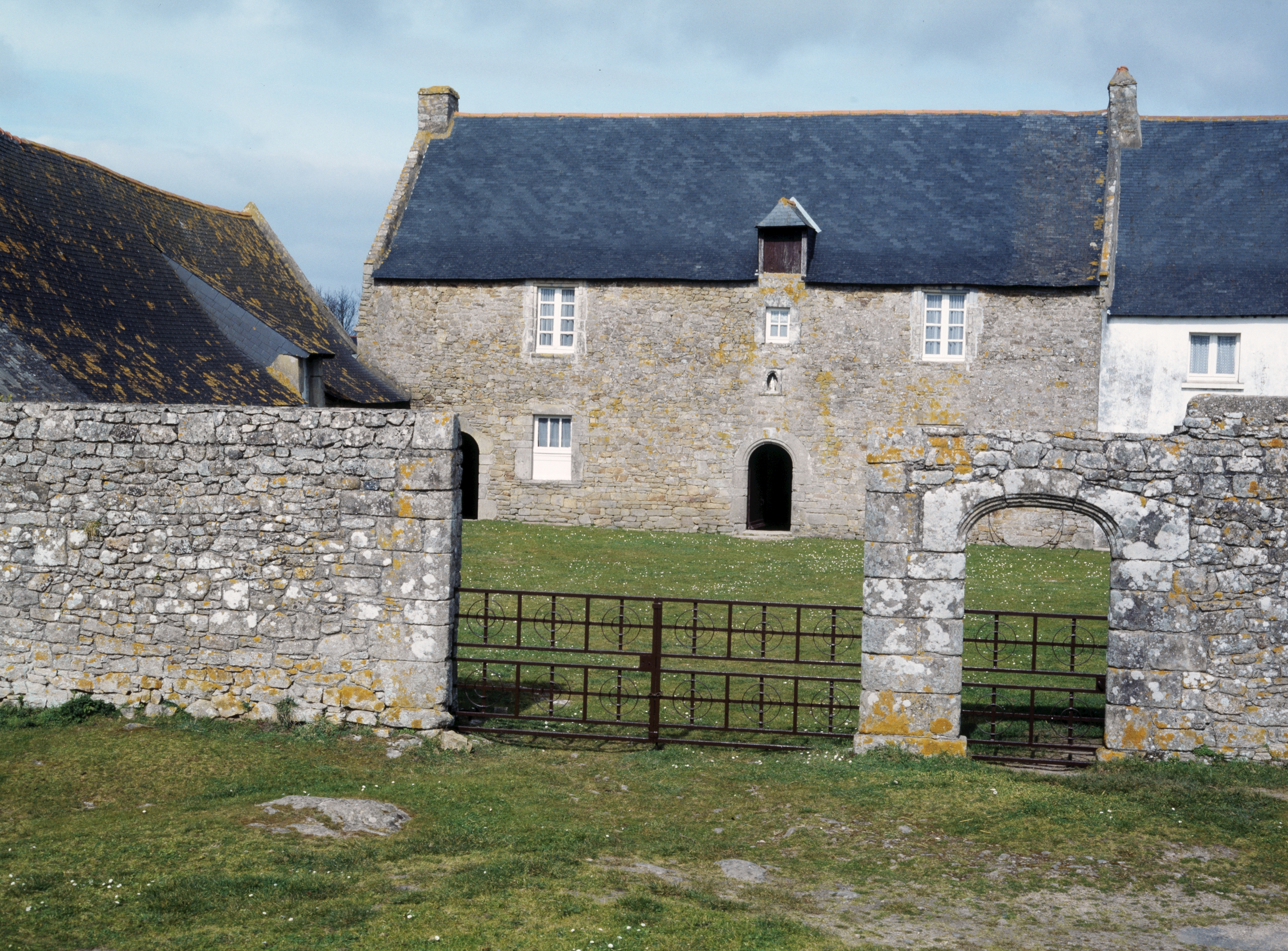 Manoir, vue générale de l'élévation sud avec mur de clôture et dépendances.