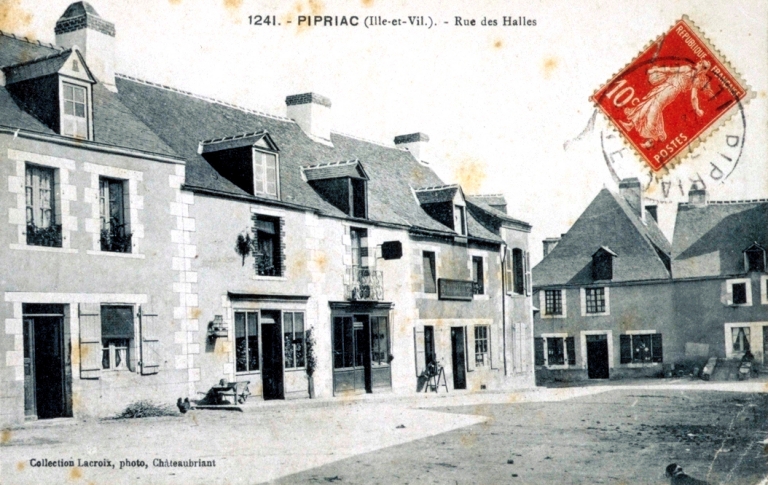 Alignement de maisons à boutiques place des Halles sur une carte postale au début du XXe siècle ; L'alignement sur une carte postale au début du XXe siècle : vue générale nord-ouest