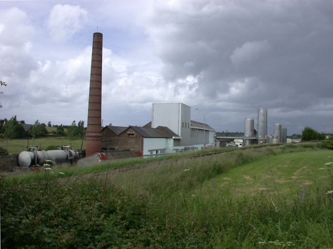 Vue générale sud-est du site. On aperçoit, au premier plan, les anciens ateliers de la distillerie (cheminée d'usine et bâtiment de la colonne de distillation), et à l'arrière plan, les ateliers et cuves de la laiterie.
