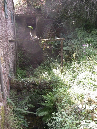 Vue générale de l'ancien coursier (et emplacement de l'ancienne chute d'eau). La roue hydraulique a disparu.