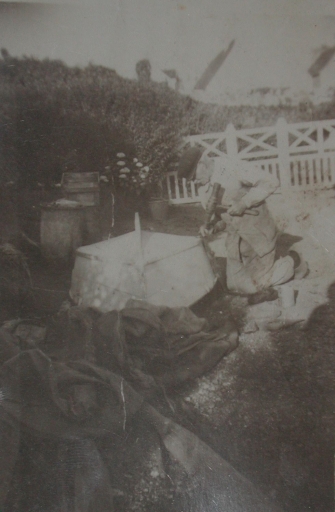 Le charpentier et maître calfat François Briand en train de calfater le bordé de bouchain d'un canot avec son maillet à calfat (collection particulière)