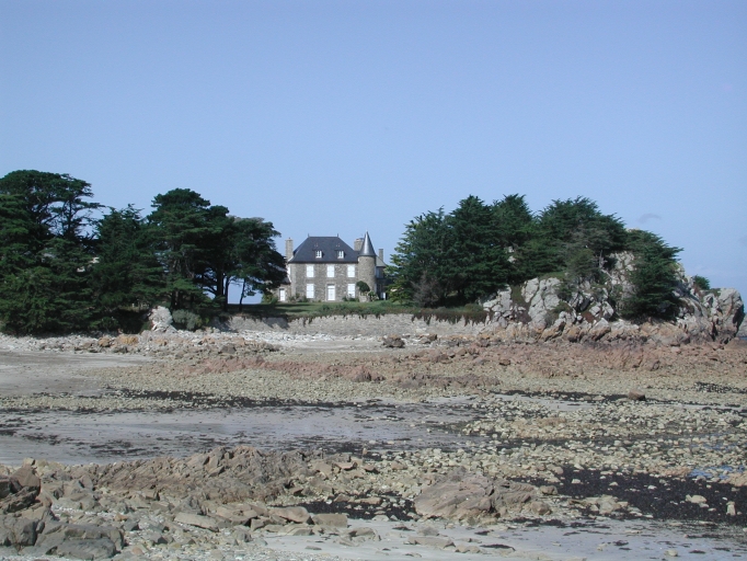 Vue du bâtiment principal de l'île avec son architecture de petit château, flanqué d'une tour et les murs de défense contre la mer