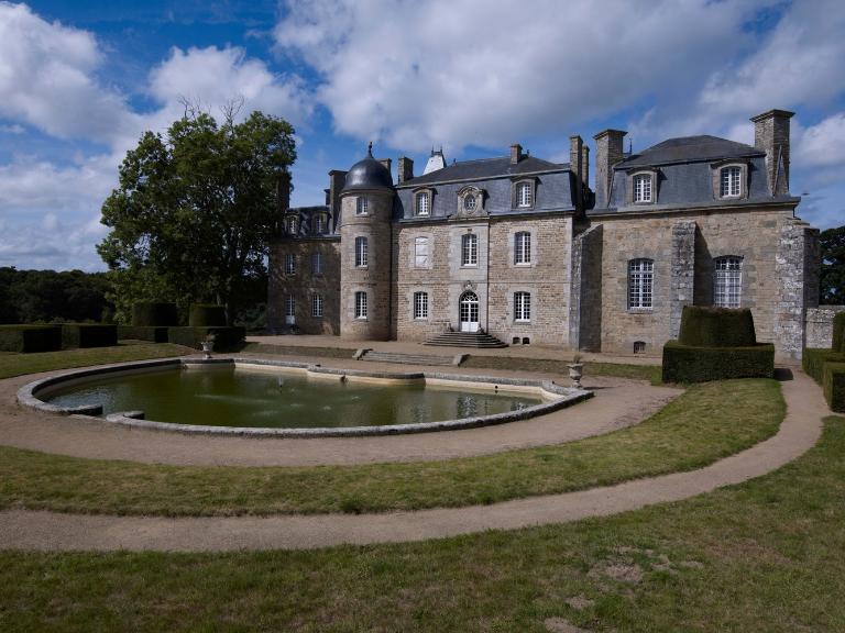 Vue générale de l'élévation orientée vers le sud-est. Au premier plan, le miroir d'eau. A droite, le chartrier encadré de contreforts