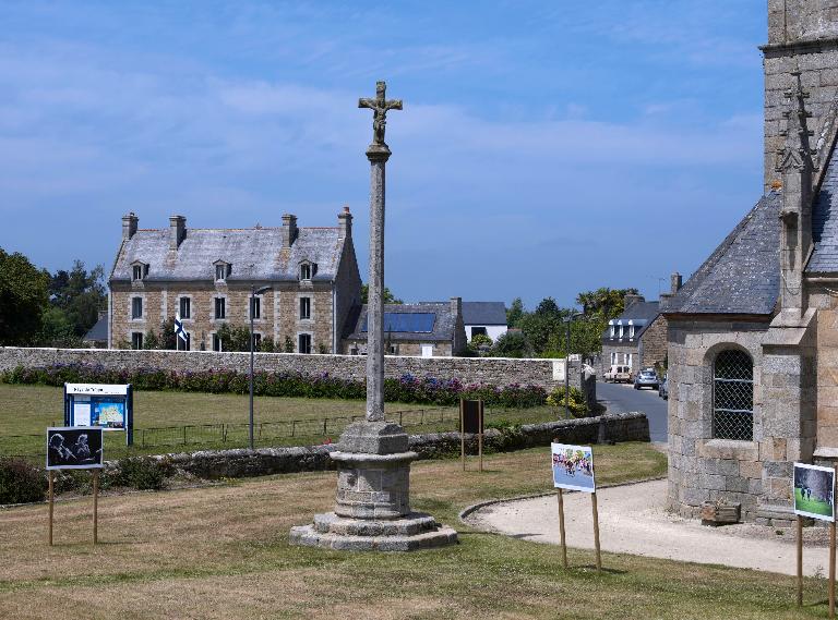 Tonquédec, le bourg, place de l'église : croix monumentale, vue générale, Christ en croix. En arrière plan : l'ancien presbytère ; Tonquédec, le bourg, place de l'église : croix monumentale, vue générale, Christ en croix. En arrière plan : l'ancien presbytère