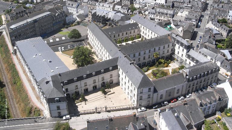 "Vue aérienne oblique  prise en 2010. Le plan en grille avec plusieurs cours séparées par les bâtiments est ici adapté à la forme de la parcelle et à la taille de l'établissement. { L'entrée originelle du lycée construit à partir de 1885 (A. Le Corre, architecte). Le plan du lycée s'inspire du modèle qui s'est développé dans les premières années de la 3e République : classes au rez-de-chaussée, dortoirs aux étages, bâtiments qui délimitent des cours bordée de ""cloitres"" (dans la continuité des couvents)."