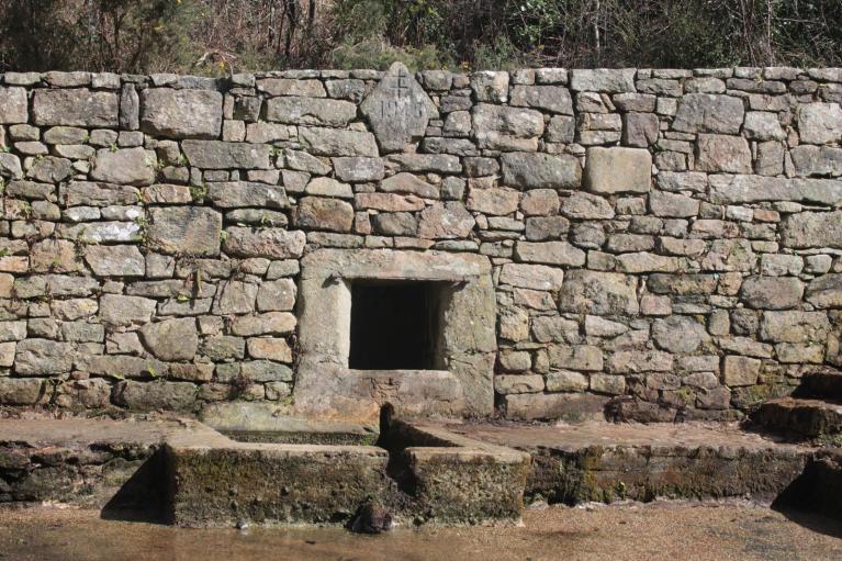 Vue générale ouest de la fontaine, du muret de soutennement et de la pierre gravée (avril 2018).