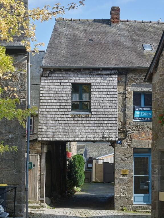 Cette maison en maçonnerie comporte un porche en pan de bois.