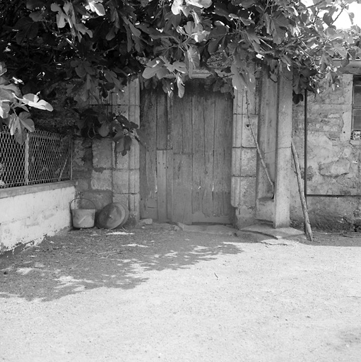 Mur de la cour à droite, porte.