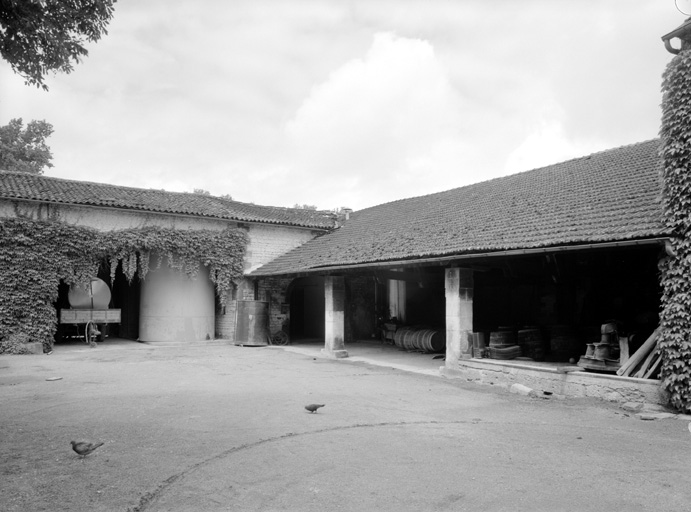 Hangar et, au fond, le bâtiment de la distillerie.