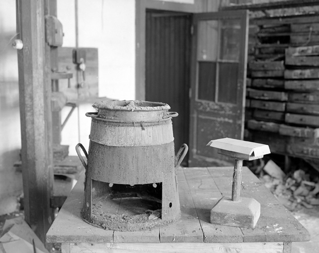 Atelier de cartonnage, pot de colle à chauffage par bec Bunzen et tourette pour montage des boites.