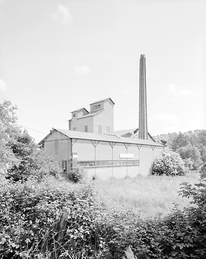 Atelier de fabrication, façade sud et la cheminée en béton.