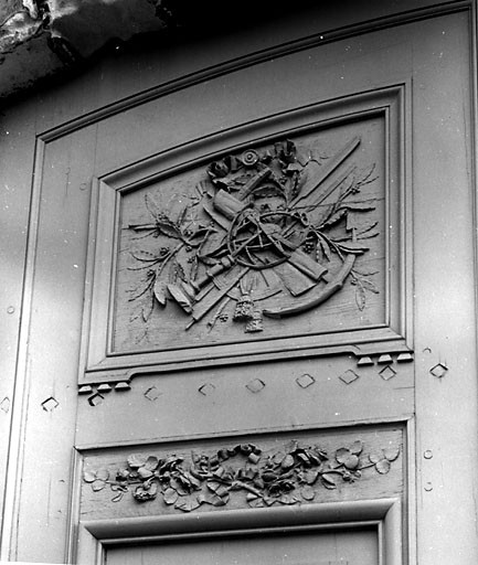 Elévation sur la rue Admyrauld, portail, vantail gauche, partie supérieure : trophée et guirlande.