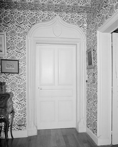 Logis, rez-de-chaussée, pièce de l'angle est : porte avec arc en accolade et écu bûché.
