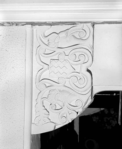 Logis, premier étage, pièce de l'angle nord, cheminée, corbeau de droite, face latérale droite : masques, rinceaux et écu losangé.
