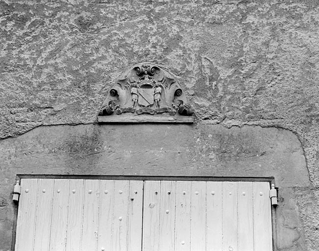 Logis, façade nord-ouest, blason des de Menou sculpté au dessus du linteau de la porte centrale.