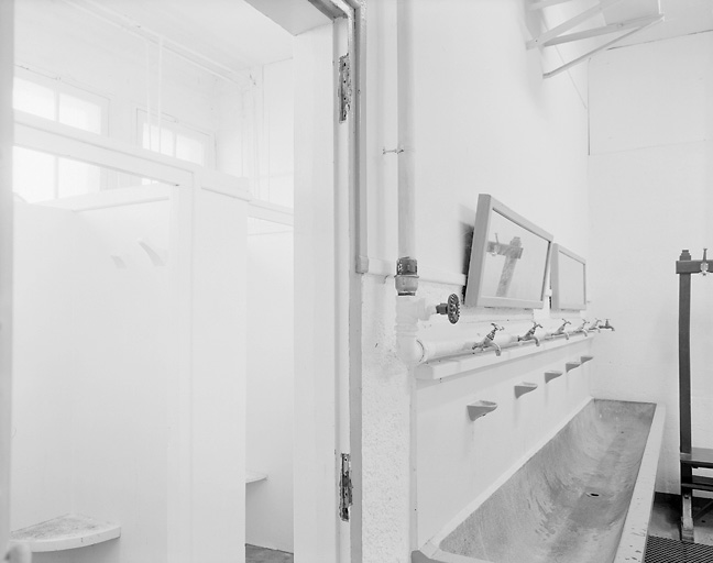 Intérieur du vestiaire : douches et lavabos.