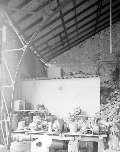 Vue intérieure du hangar de goudronnage des fûts ; détail de la retombée d'une ferme métallique.