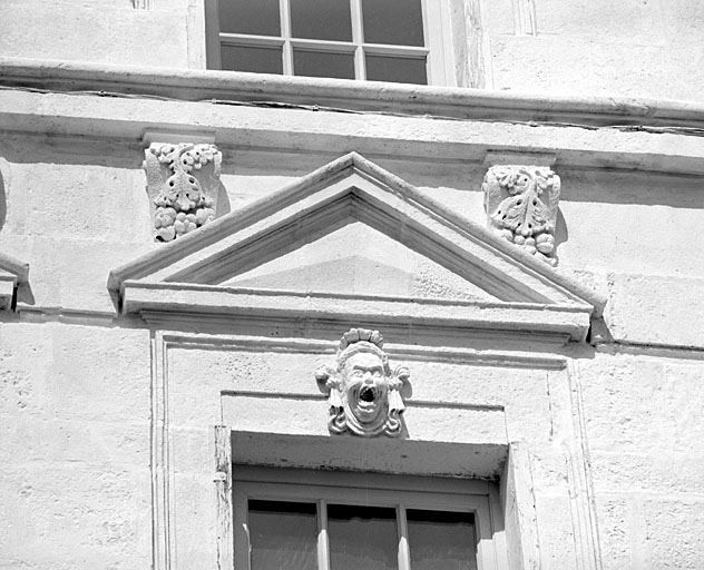 Façade, deuxième niveau, fronton de la première fenêtre à droite.