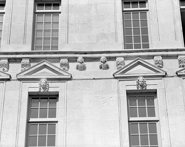 Façade, deuxième niveau, fronton des troisième et quatrième fenêtres depuis la droite.