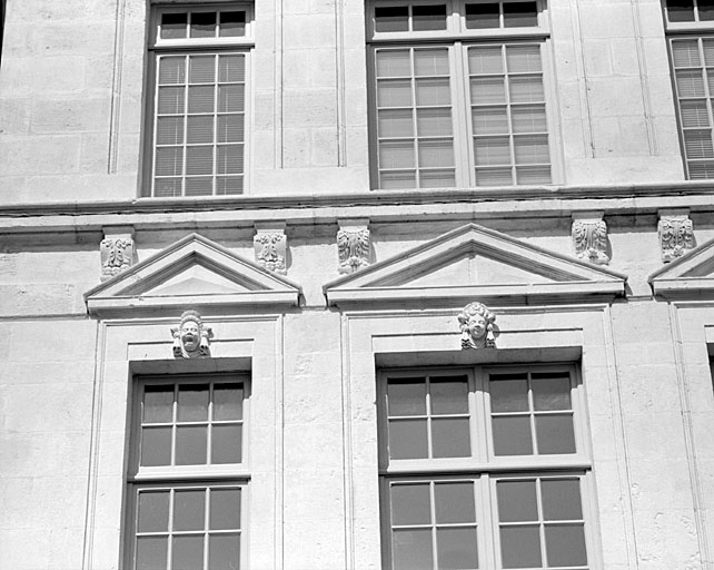 Façade, deuxième niveau, fronton des deux fenêtres de gauche.