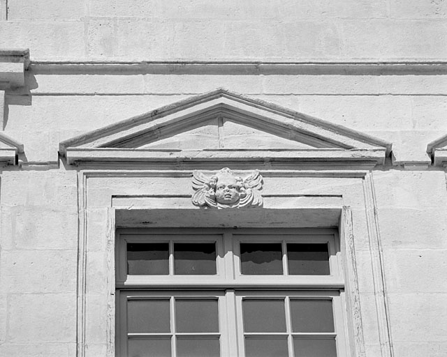 Façade, troisième niveau, fronton de la deuxième fenêtre à droite.