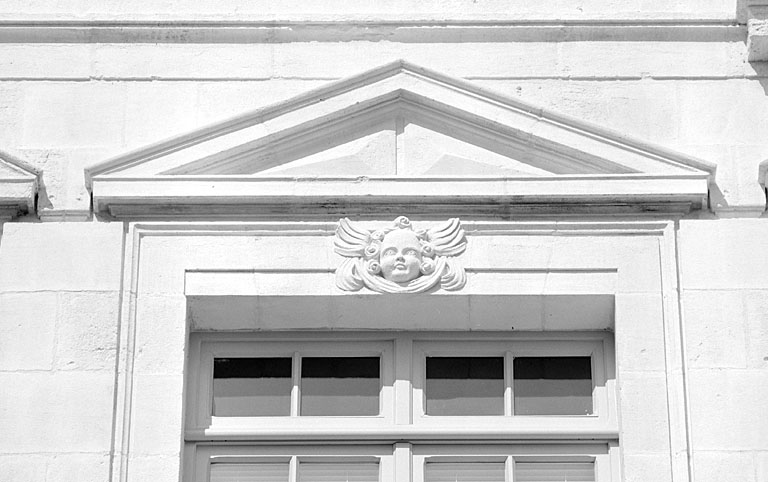 Façade, troisième niveau, fronton de la deuxième fenêtre depuis la gauche.