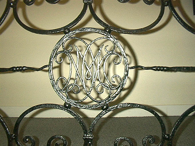 Escalier, premier étage, rampe en ferronnerie, détail du chiffre.