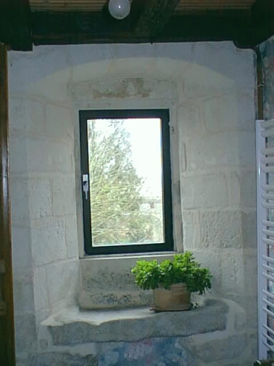 Logis de la métairie noble, premier étage, pièce transformée en salle de bains, baie couvert d'un arc déprimé.