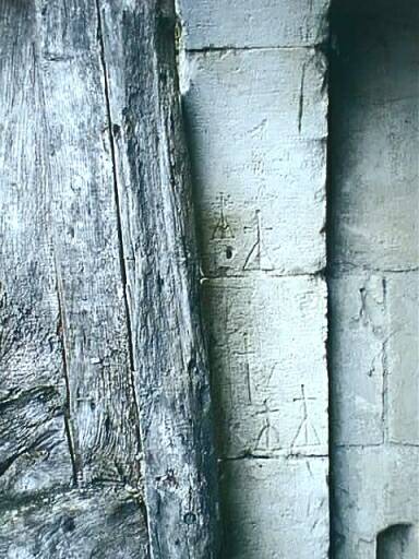 Dépendances ouest sur cour, élévation est, écurie, porte, détail des graffitis sur le jambage gauche.