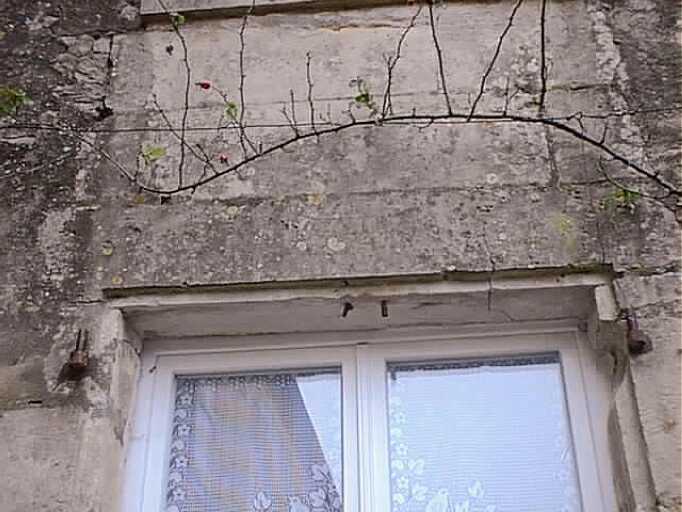 Logis, élévation sud sur cour, rez-de-chaussée, fenêtre de gauche, linteau daté 1613.